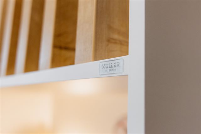 Kovový štítek Müller na nábytku