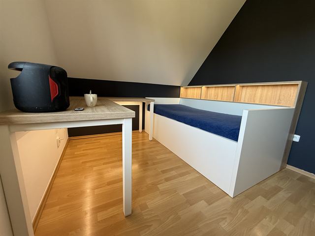 Postel a stůl pod šikminou